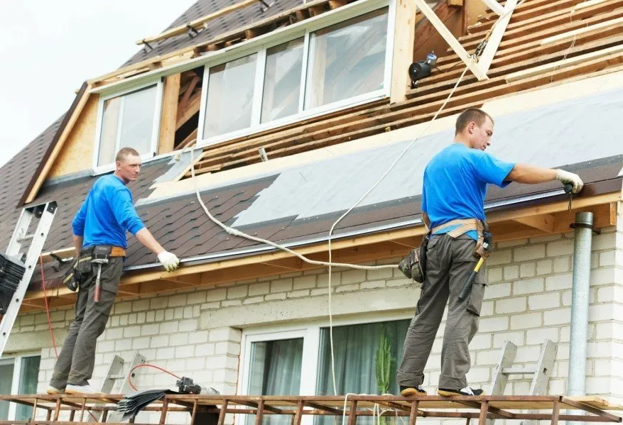 Two men working on roof to install underlayment