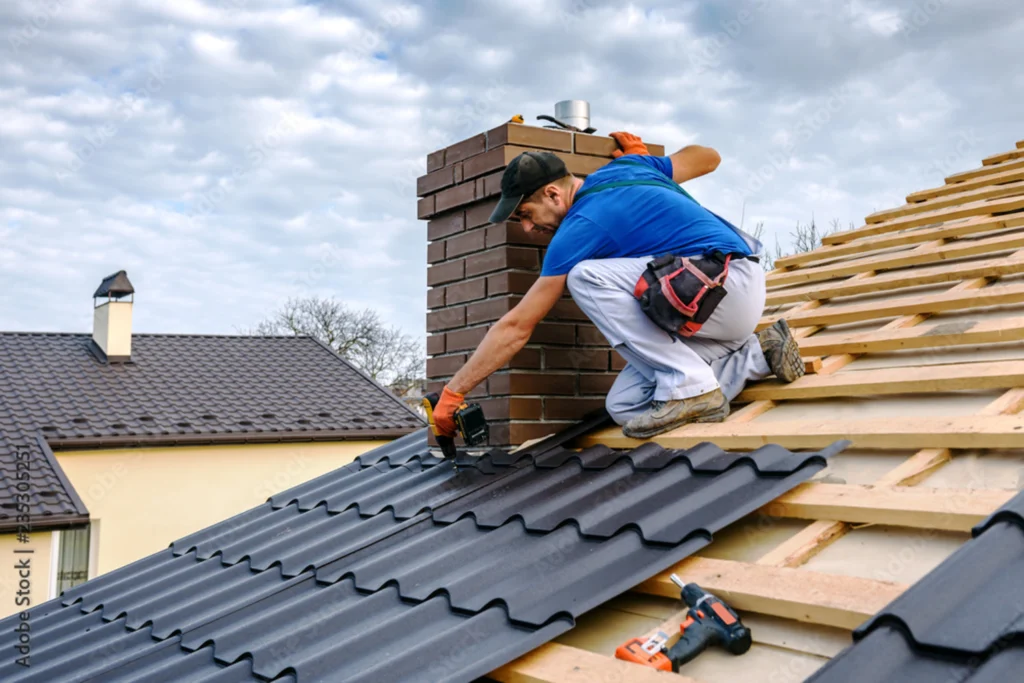 man with hard hat standing on steps inspecting house roof